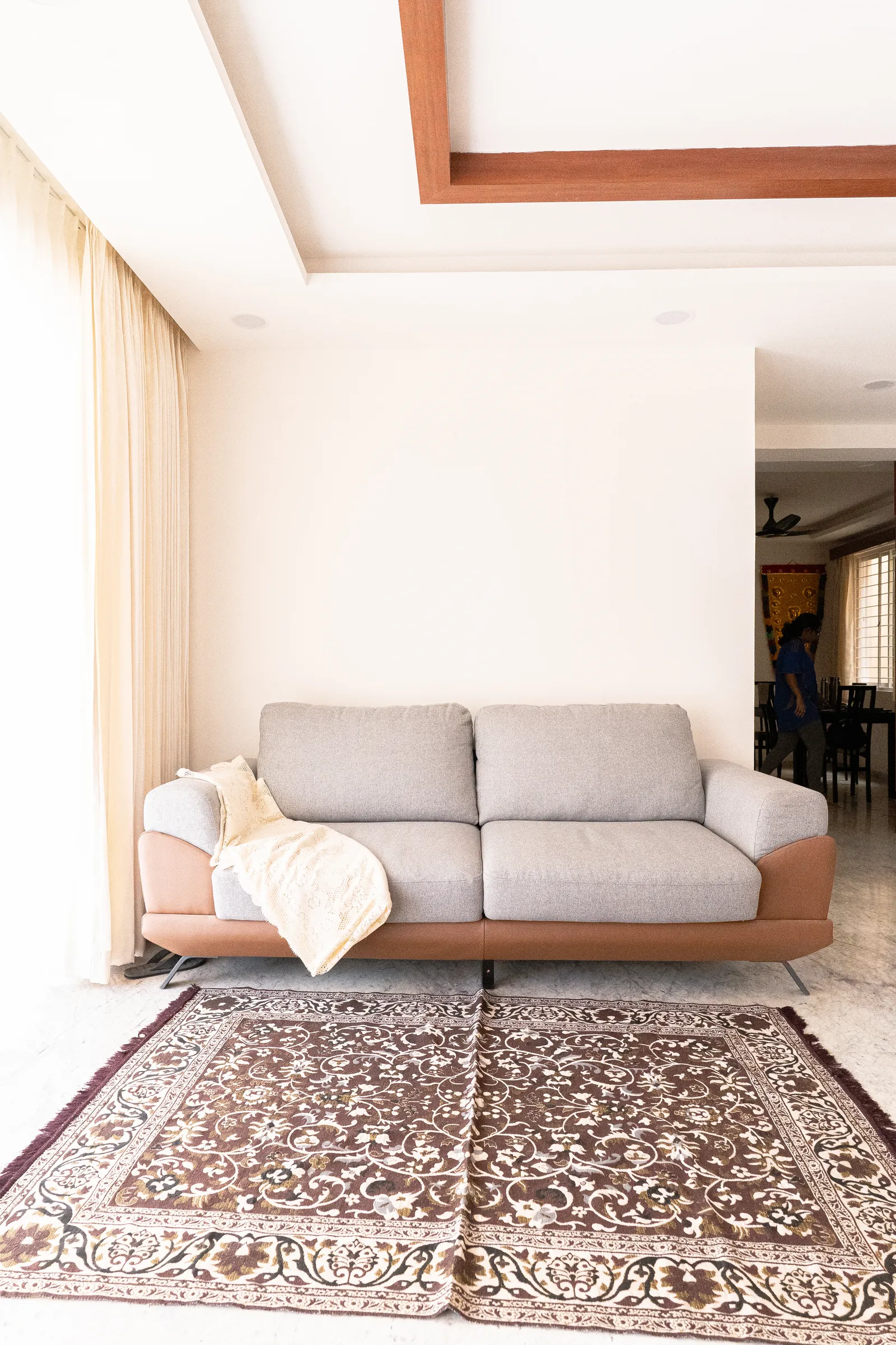 Living area with grey sofa and timber ceiling trim — Karthik's Residence